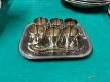 a silver tray with six cups on it