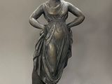 bronze statue of a woman holding a vase on a pedestal
