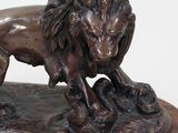 bronze statue of a lion on a wooden base on a white background