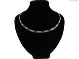 collier de perles noires et blanches autour du cou d'un mannequin