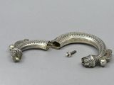 two silver bracelets with fish heads on them on a gray surface