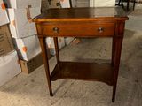 a small table with a drawer on it in a room