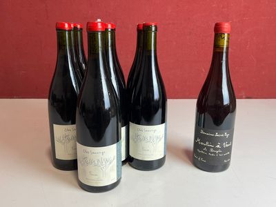 quatre bouteilles de vin sont alignées sur une table