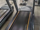 a row of tread machines in a gym room