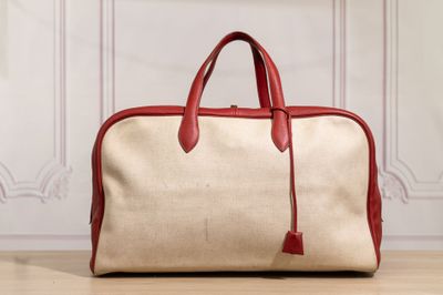 a red and beige bag sitting on a wooden floor