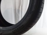 a close up of a tire on a white surface with a white curtain in the background