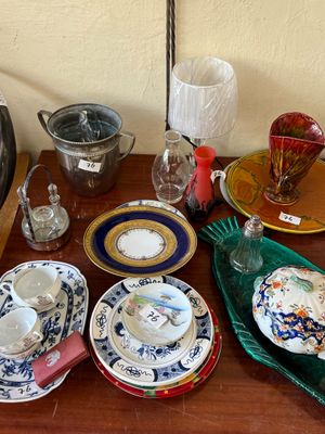 many plates and cups on a table with a lamp