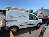 une camionnette blanche garée dans un parking à côté d'autres véhicules