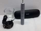 an electric toothbrush sitting next to a glass of water on a table