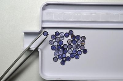 un plateau sur lequel se trouvent quelques pierres bleues et une paire de ciseaux