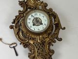 une horloge accrochée au mur, à laquelle est attachée une clé