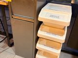 une pile de récipients posée par terre devant un réfrigérateur