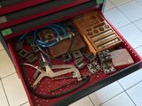 une boîte à outils rouge contenant des outils, posée sur un sol carrelé