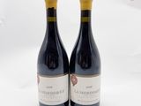 deux bouteilles de vin rouge posées l'une à côté de l'autre sur une surface blanche
