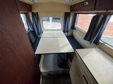 a view of the inside of a camper with a table and chairs