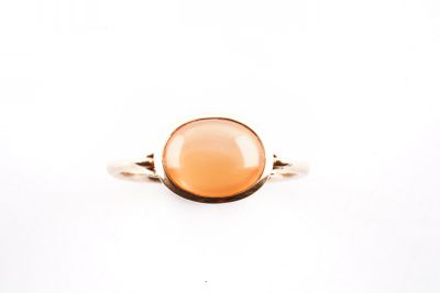 Gros plan sur une bague contenant une pierre orange