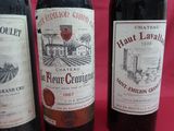 three bottles of red wine are lined up on a table