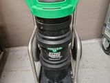 une photo d'un aspirateur vert et noir posé sur un chariot