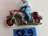 une figurine représentant un homme à moto, sur laquelle figure un numéro