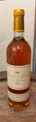 une bouteille de whisky posée sur une table à côté d'une bouteille de vin