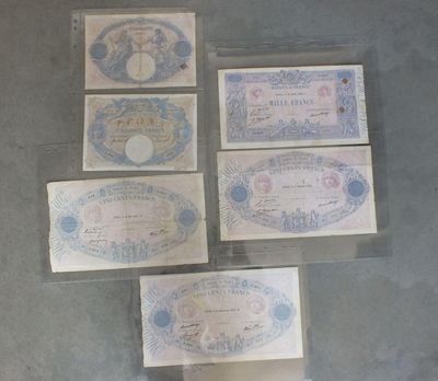 cinq billets différents, de formes et de tailles variées, sont posés sur une table