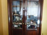 un meuble en bois avec une porte en verre dans une pièce