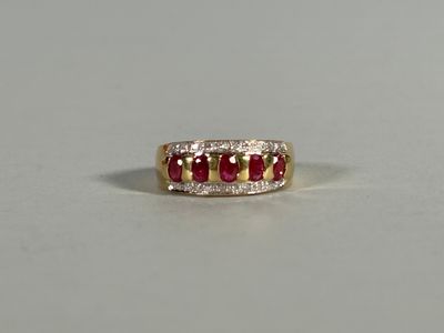 a close up of a gold ring with three ruby stones