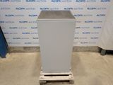 a white refrigerator sitting on top of a pallet in front of a wall