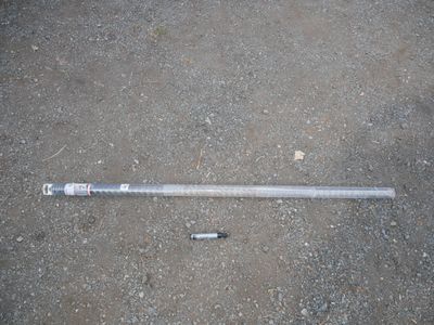 a baseball bat laying on the ground next to a bottle of beer