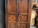 a wooden armoire with carvings on it in a room