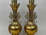 une paire de vases anciens en laiton, ornés chacun de motifs élaborés