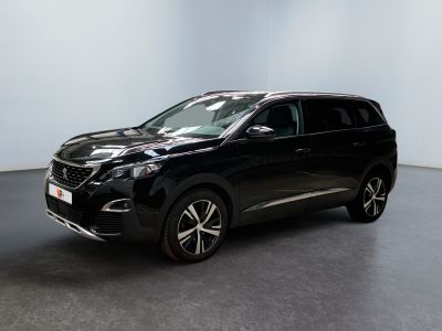 Le SUV Nissan noir est garé dans une pièce blanche