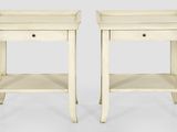 une paire de tables d'appoint blanches avec des tiroirs de chaque côté