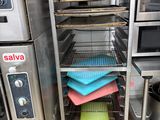 several trays of food are stacked on a rack in a commercial kitchen