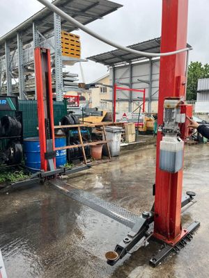 un homme debout à côté d'un poteau rouge auquel est fixé un tuyau
