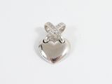 un pendentif en forme de cœur en argent orné d'une croix