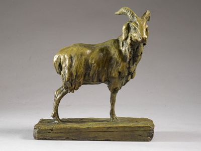 bronze statue of a goat on a wooden base against a gray background