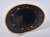 a black hat with a brown band on a white surface