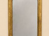 un miroir ancien dans un cadre doré accroché au mur d'une pièce