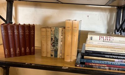 de nombreux livres sur une étagère sur laquelle sont posées une paire de ciseaux