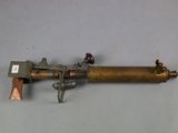 an old brass pipe with a brass handle on a gray surface