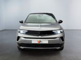 the front view of a silver car in a white room