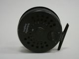 a close up of a fishing reel on a white surface