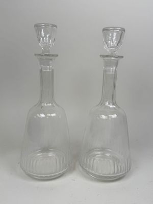 two clear glass vases sitting on top of a white table