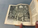 someone is holding an open book with a picture of a group of people in it