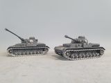 two toy tanks sitting side by side on a white surface