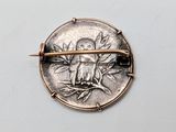 a silver coin with a bird on it on a white surface