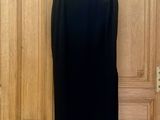 une jupe crayon noire suspendue à une porte en bois dans une pièce