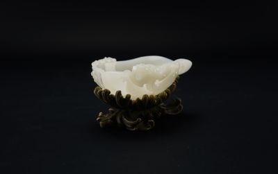 un bol blanc en forme de fleur posé sur une table noire