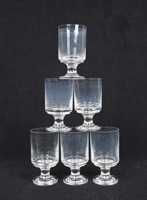 six verres à vin transparents empilés les uns sur les autres sur un fond noir